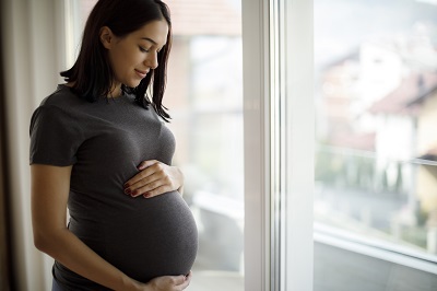 pregnant woman standing by the window